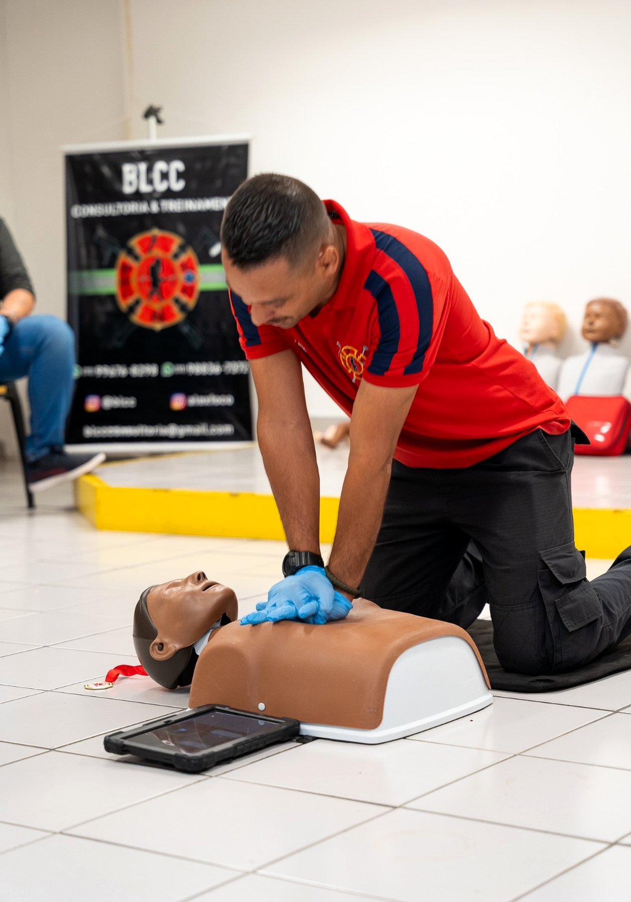 Instrutor demonstrando compressões torácicas em manequim de treinamento